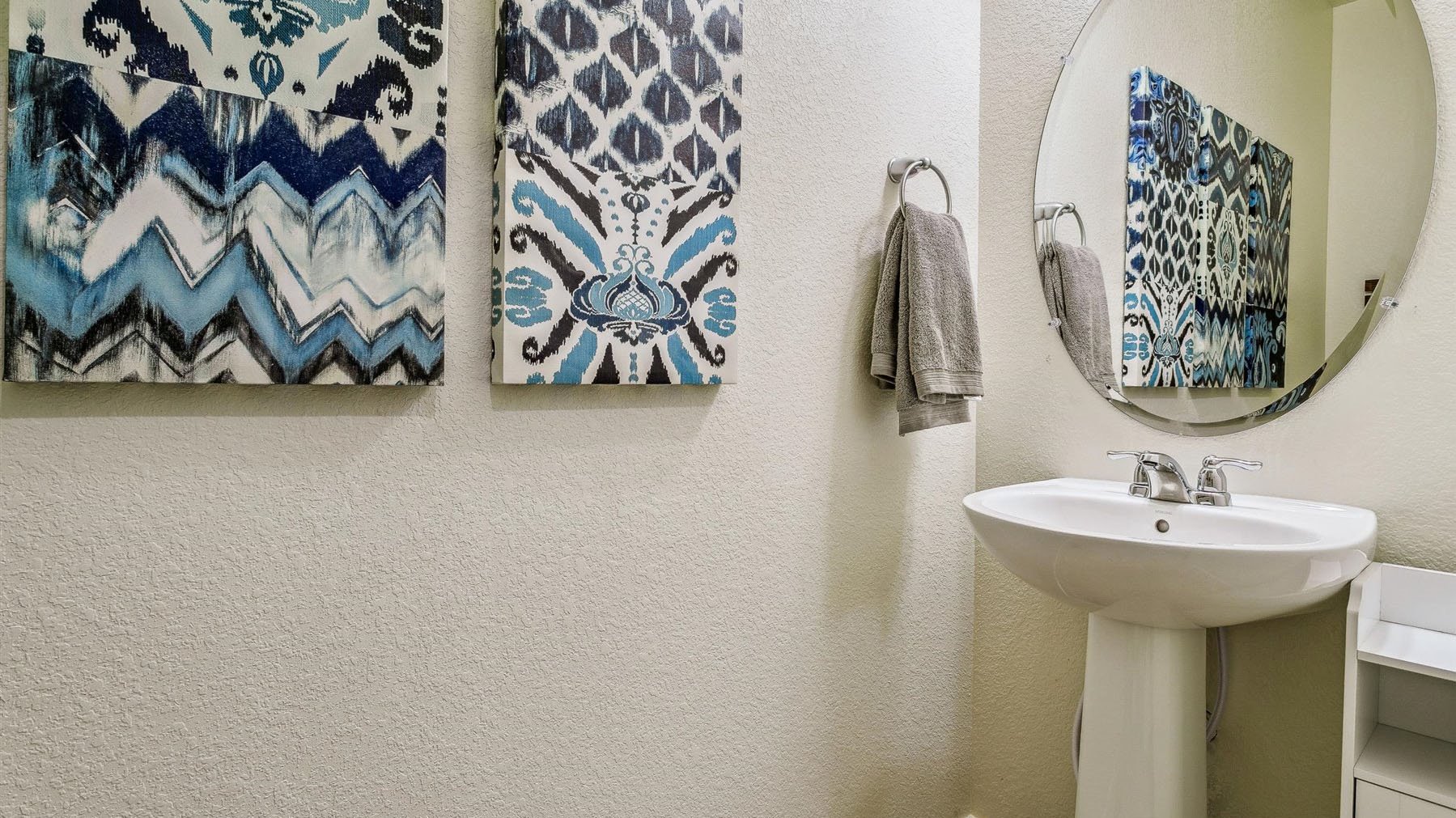 Main floor powder room with pedestal sink and chrome finishes