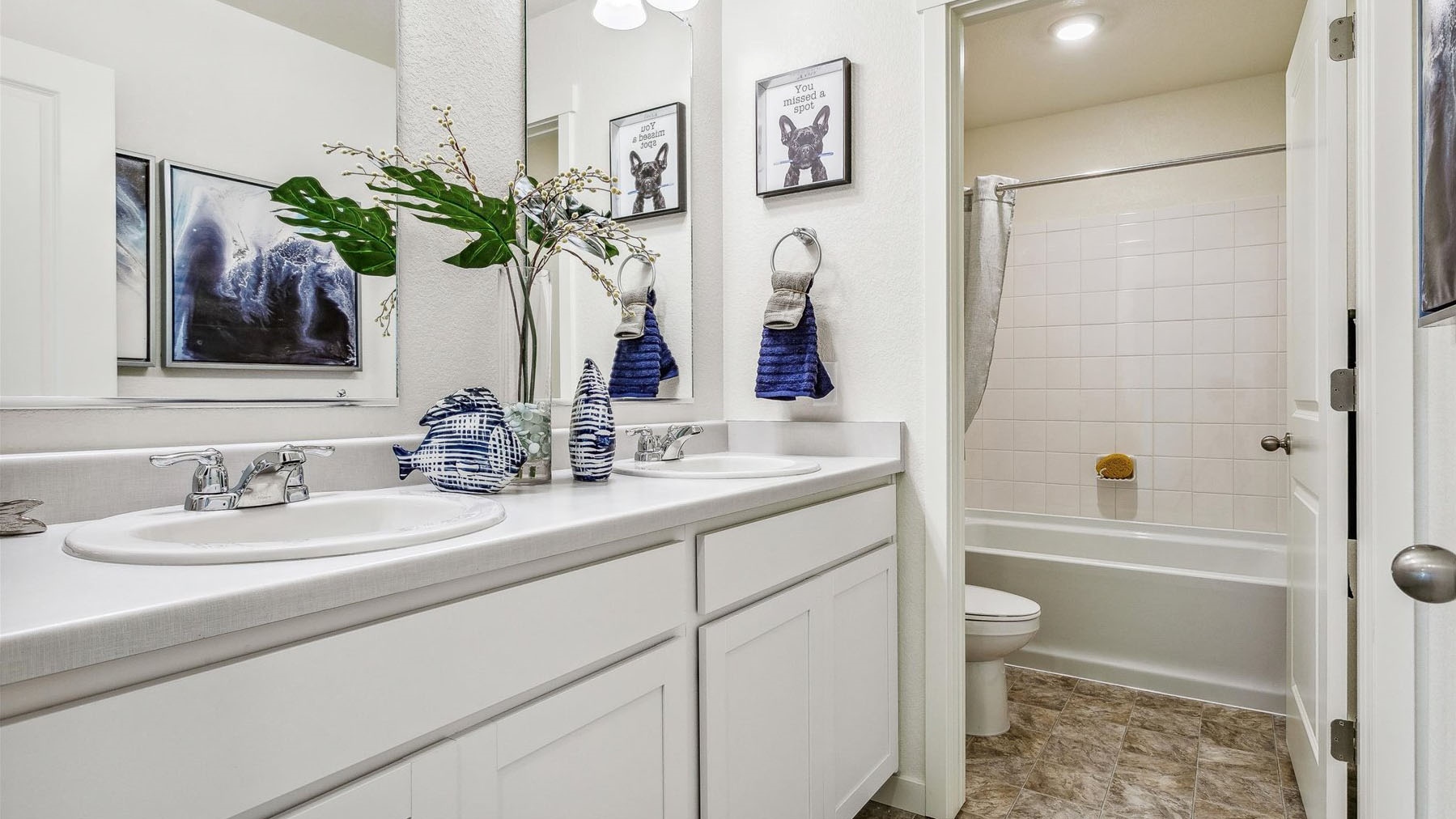 Secondary upstairs bathroom located in between bedrooms and across from laundry with shower/tub combo and double sinks