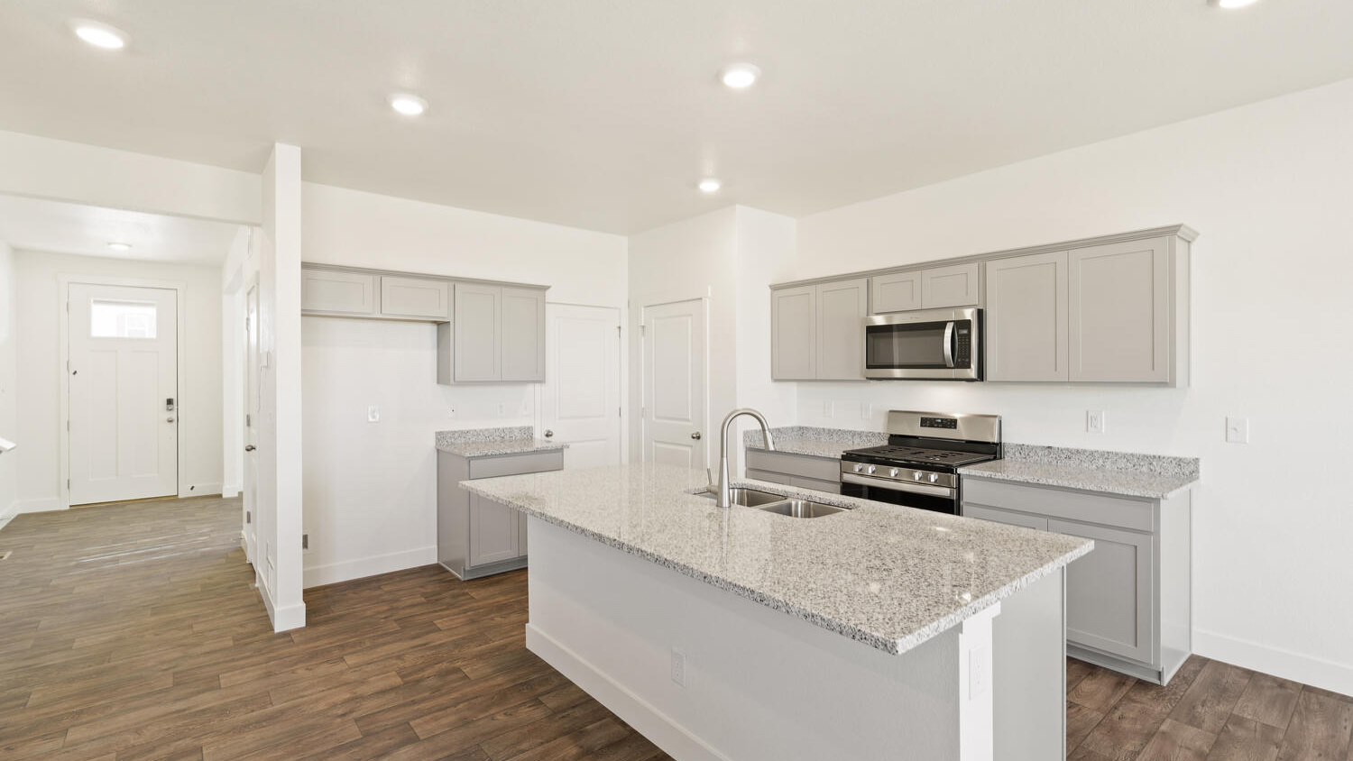 Wide angle view of kitchen showing pantry and mechanical room doors, and foyer