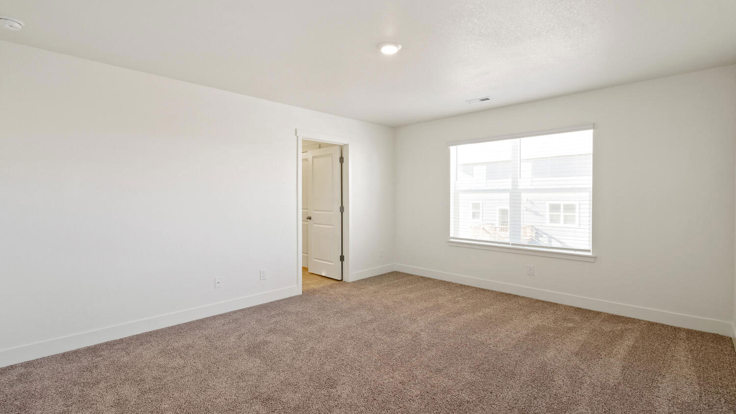 Alternate view of spacious primary bedroom and private bathroom door