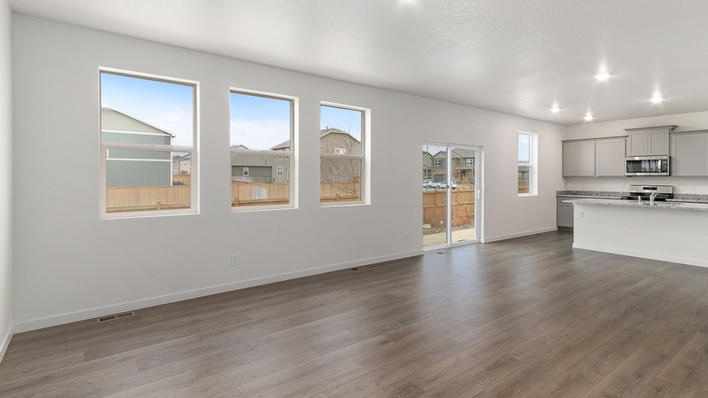 Four windows and a sliding patio door with outdoor access in this open living area