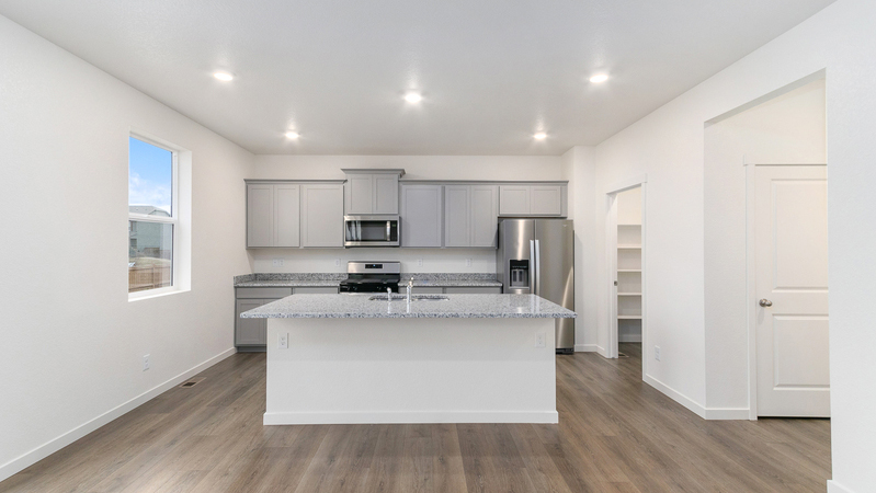 Functionally laid out kitchen with ample lighting and a pantry for additional storage