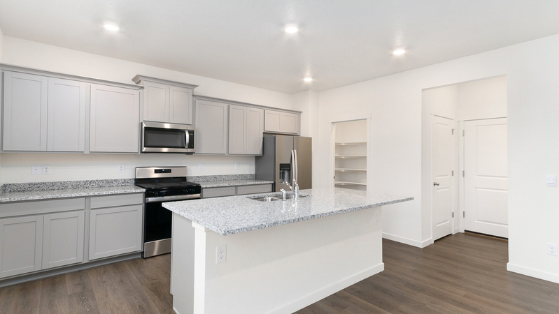 Angle view of kitchen showcasing designer cabinets, modern features, and pantry
