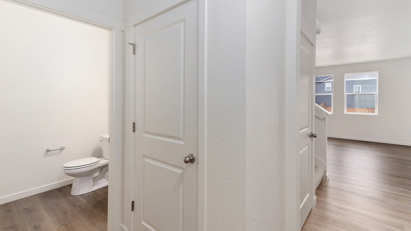 Corner view of powder room, coat closet, and stairwell