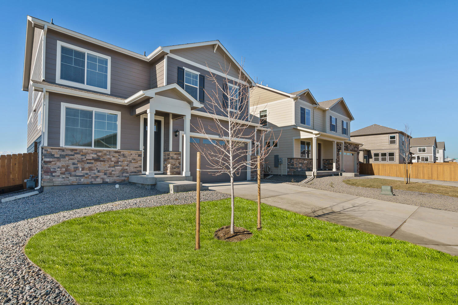 Outdoor angle with front grass lawn in foreground and second C3 home adjacent to this one