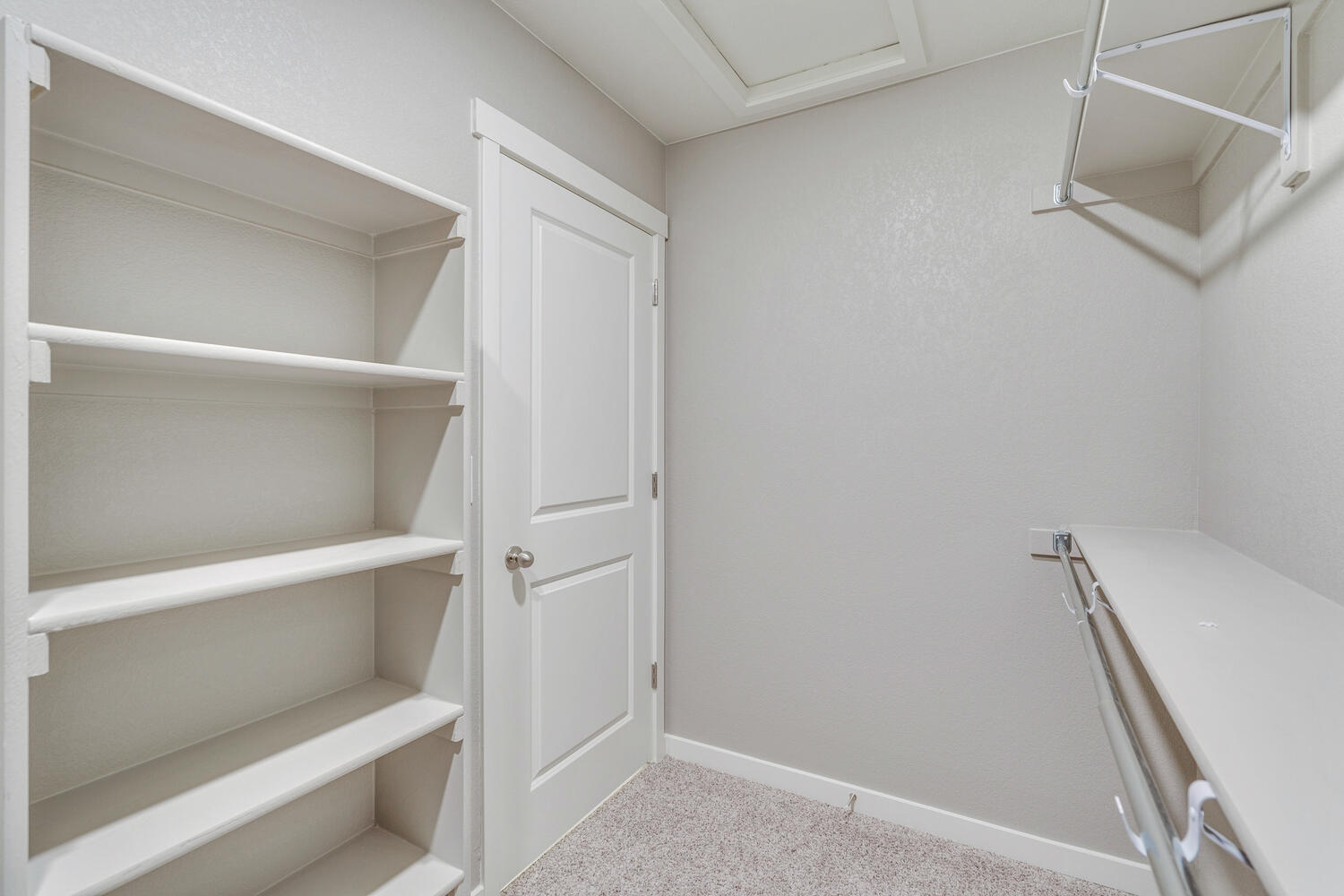 En suite bathroom walk-in closet with shelving and attic access