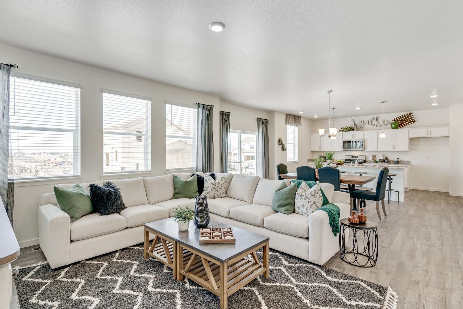 The Bridgeport plan included a comfy staged family room with the kitchen and dining area in the back.