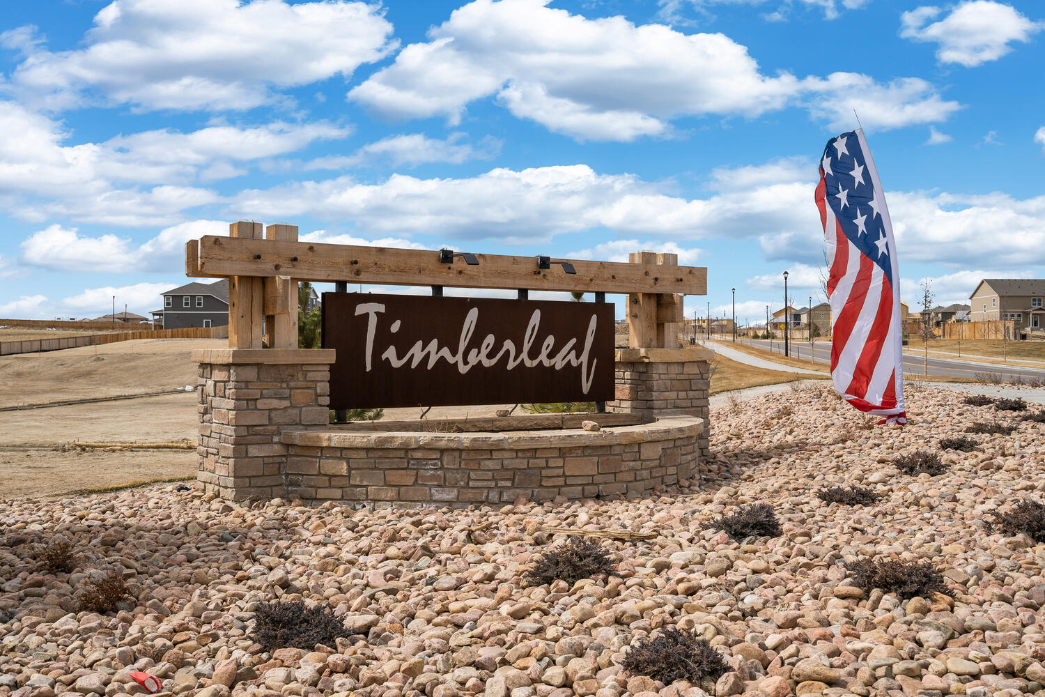 Mixed-media Timberleaf monument and american flag banner atop a bed of stones