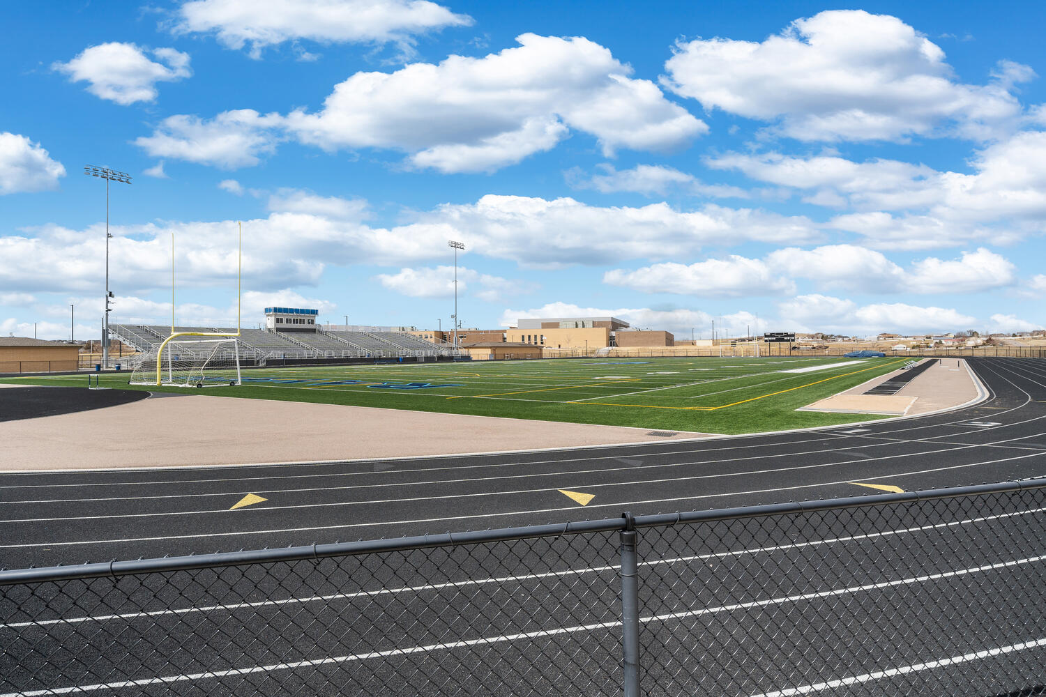 Large sports field, sand pits and track on high school grounds