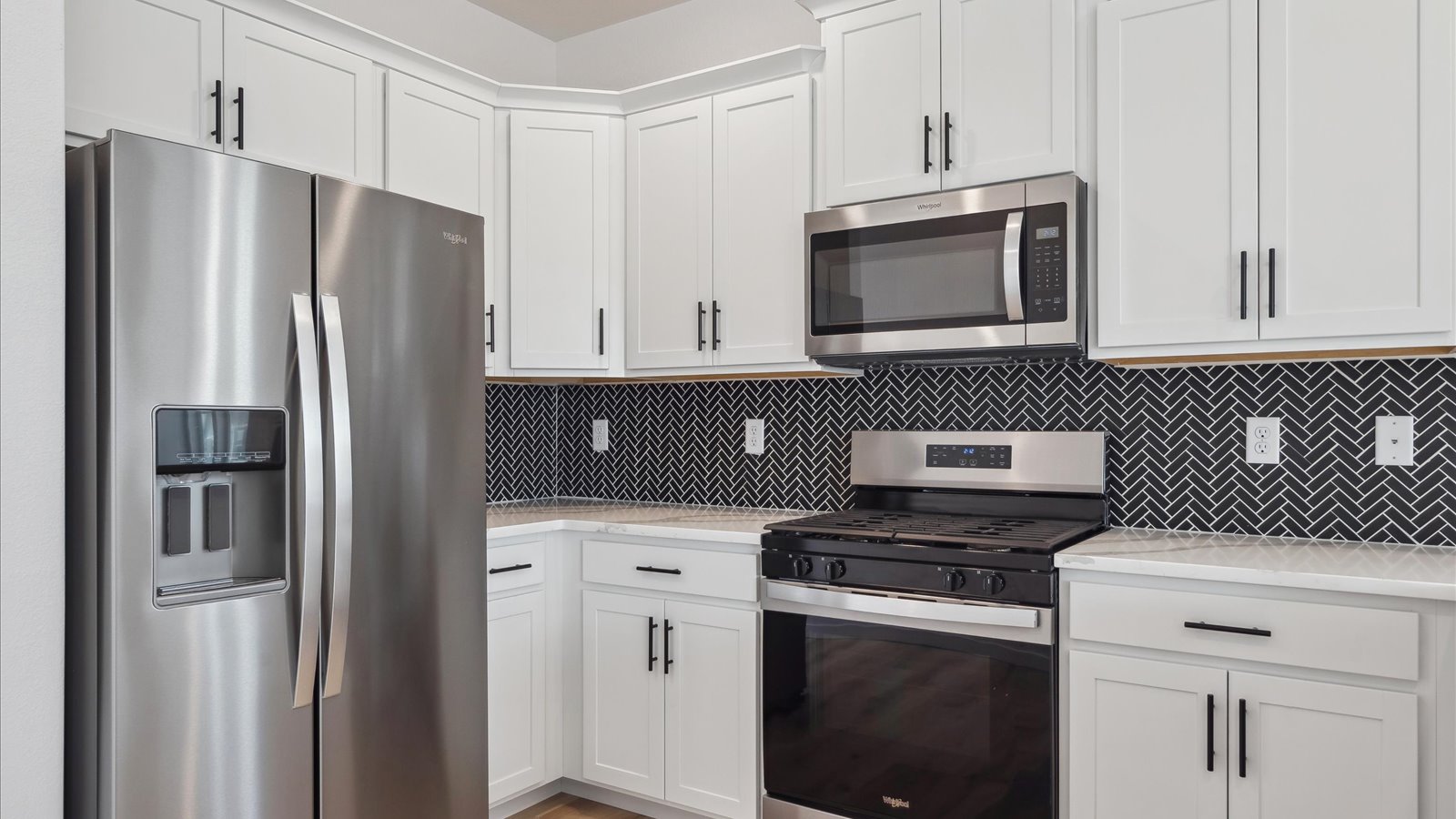 Modern kitchen with white cabinets and black tiles