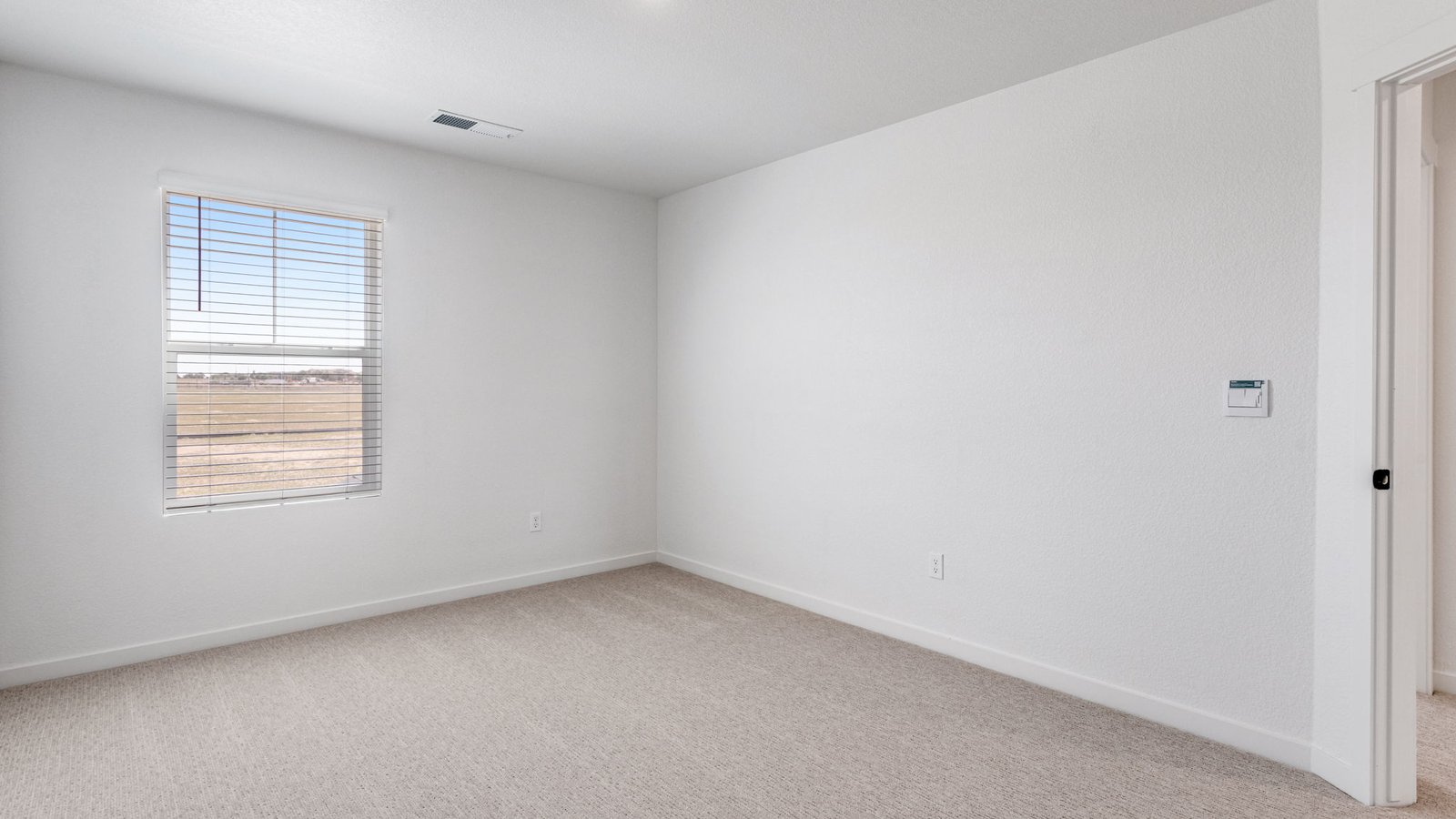 Secondary bedroom with large windows in new home at Horizon Uptown new home community