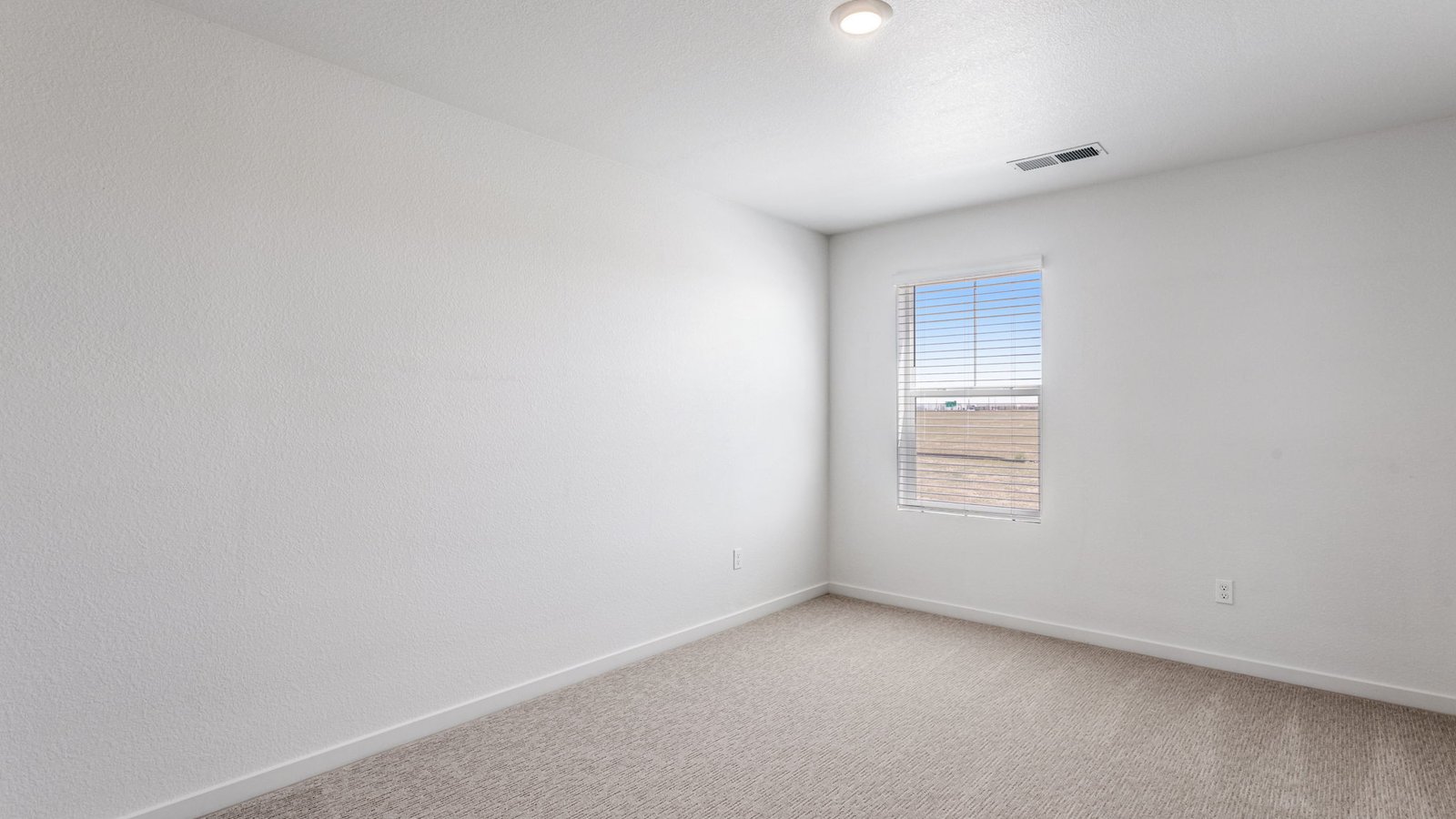 Secondary bedroom with large windows in new D.R. Horton home in Aurora, Colorado