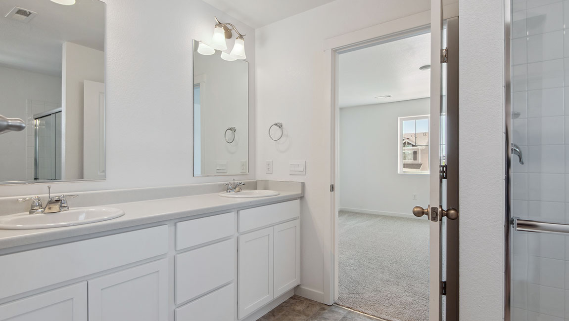 Rotated view of private bathroom in Douglas primary ensuite with double sink vanity, and generous cabinet storage space