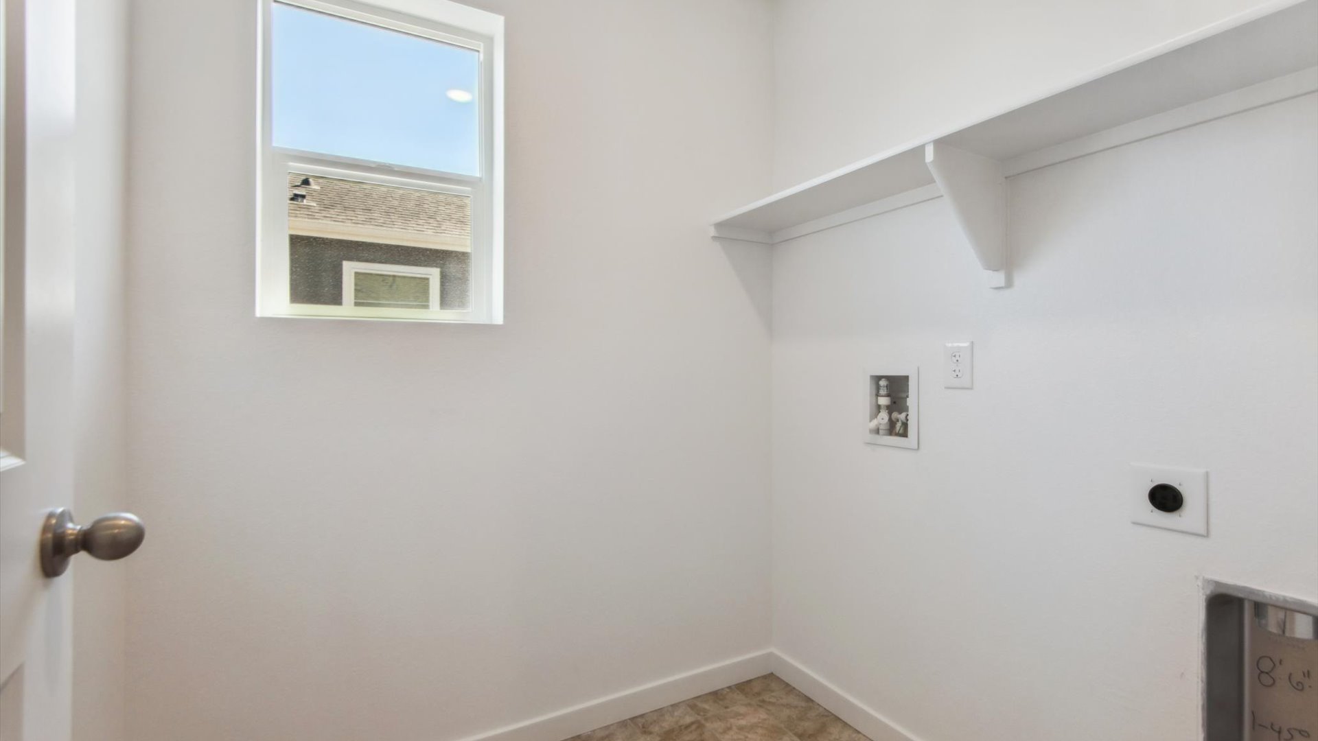 New Douglas home laundry room with operational window, built-in shelf, vinyl flooring and white door with satin-nickel knob