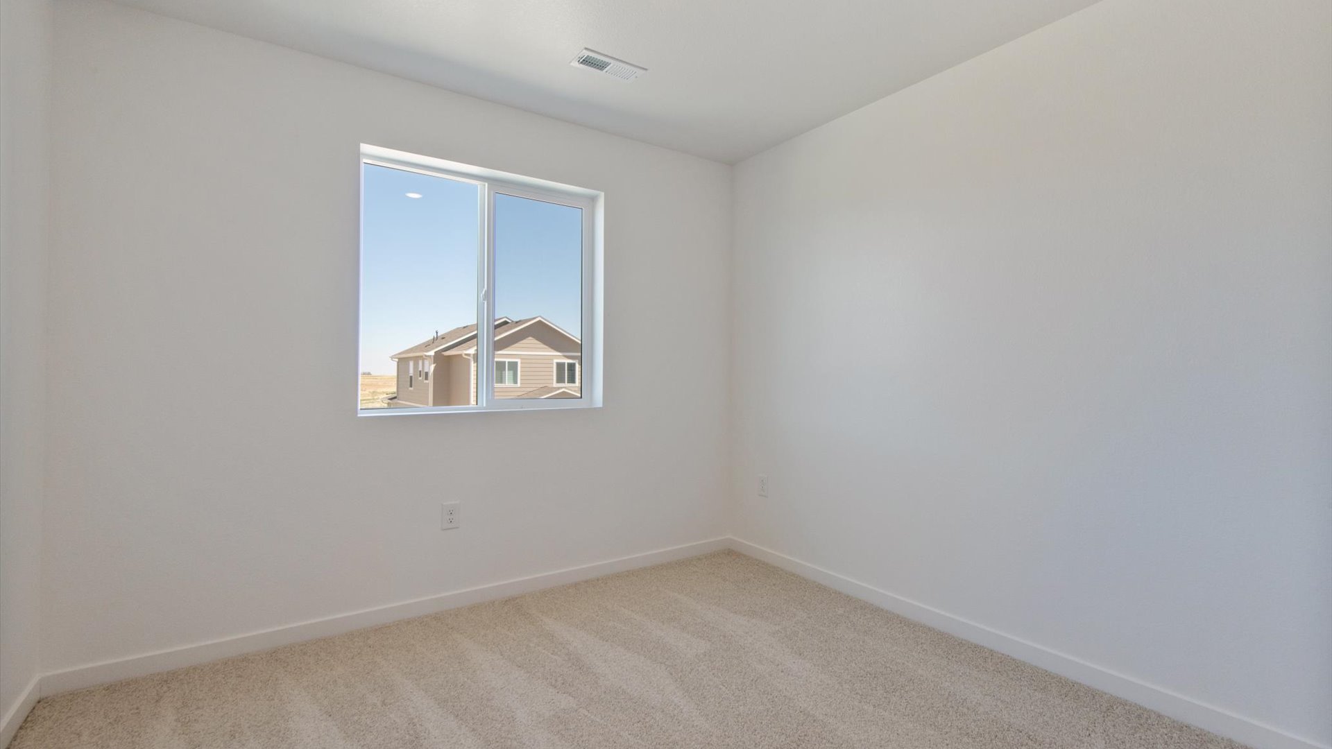 Secondary bedroom in the Douglas home plan featuring plush carpeting, operational window and multiple power outlets