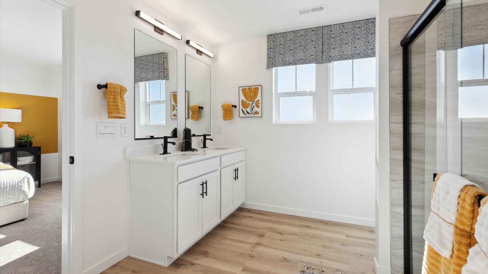 Larimer model home primary bedroom provides a private bath with double undermount-sink vanity and step-in shower