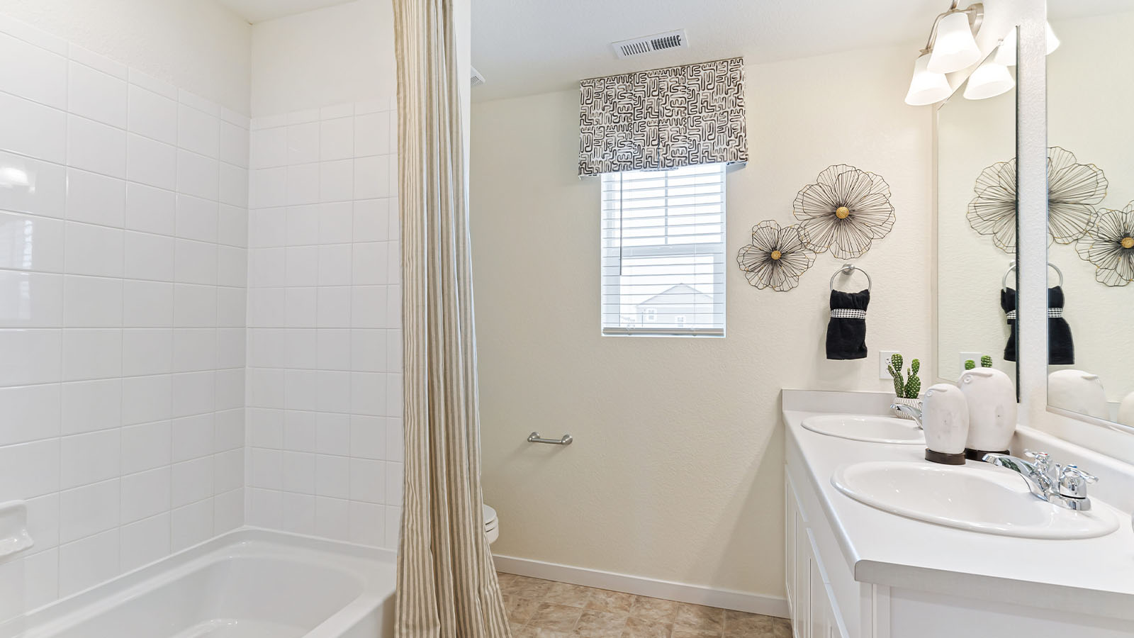 Shared hallway bathroom in Horizon Uptown model home with combination tub shower, double sink vanity and gridded window