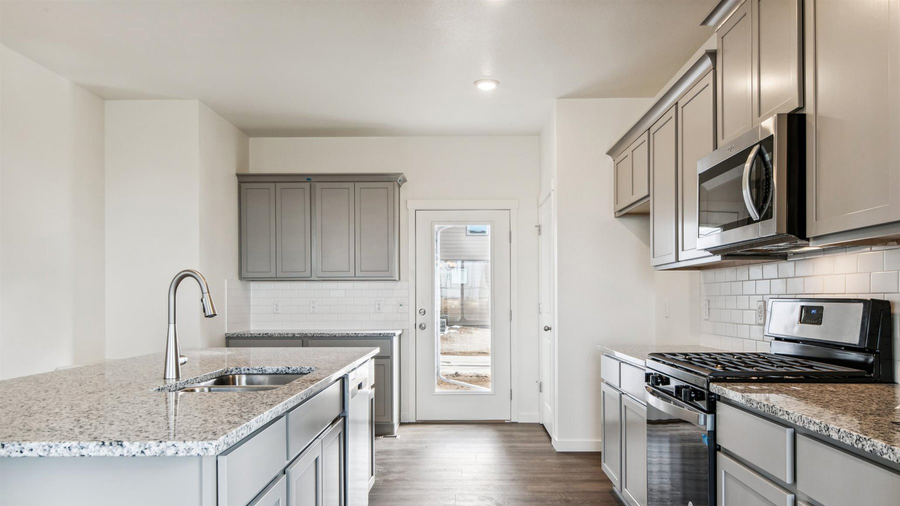 Elbert design kitchen displaying central island with undermount sink, ample cabinetry and stainless steel appliances