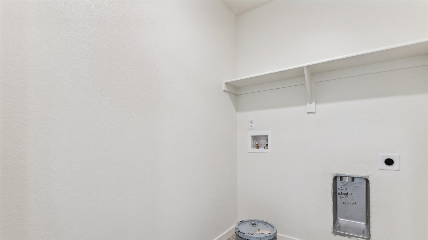 Elbert home design upstairs includes a centrally located laundry room with vinyl flooring and convenient built-in shelf above