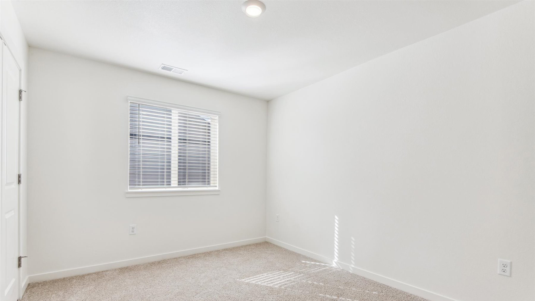 Secondary bedroom #4 in the Elbert home at Horizon Uptown with natural light spilling through its window and closet at left