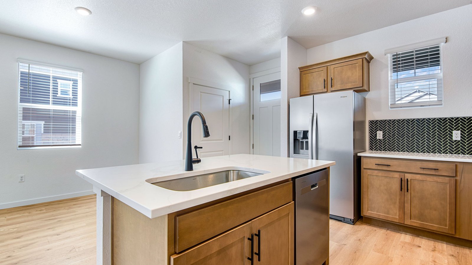 Stylish kitchen design with dark wood-toned cabinets and matte black accents, offering a modern, cohesive look.
