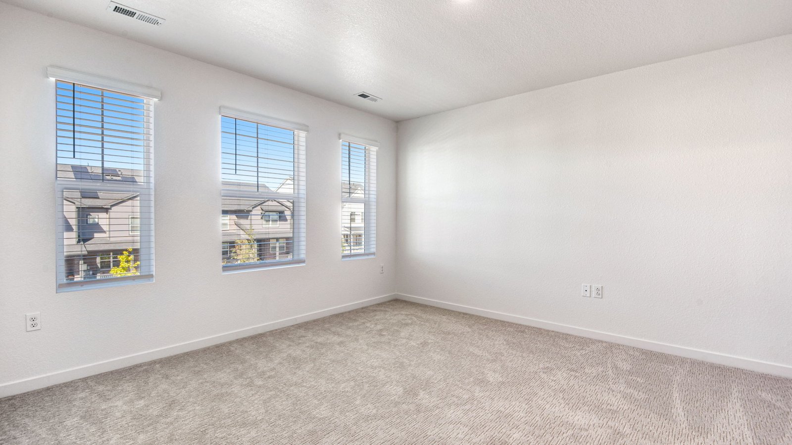 primary bedroom with large windows in new construction home by D.R. Horton