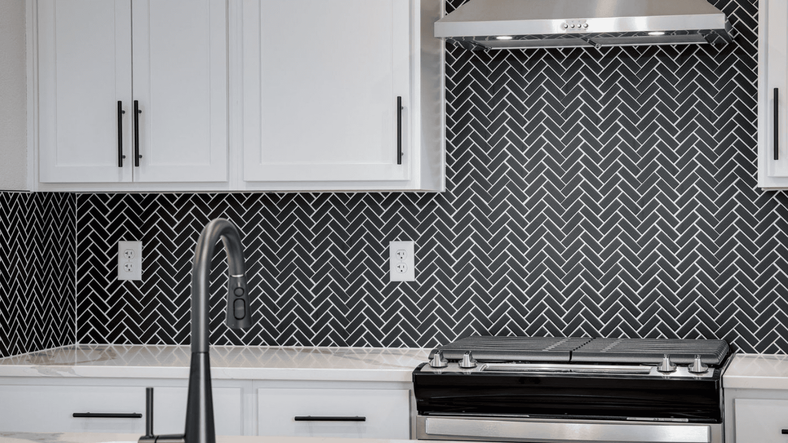 Modern kitchen with white cabinets and black backsplash in new D.R. Horton home Fort Collins, CO