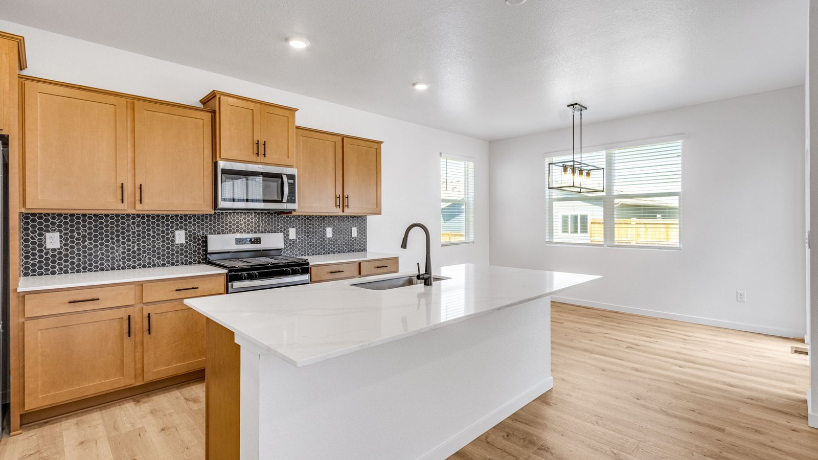 Modern kitchen in the Edmon home at Prairie Song with stylish finishes, generous cabinetry, and an open-concept design.