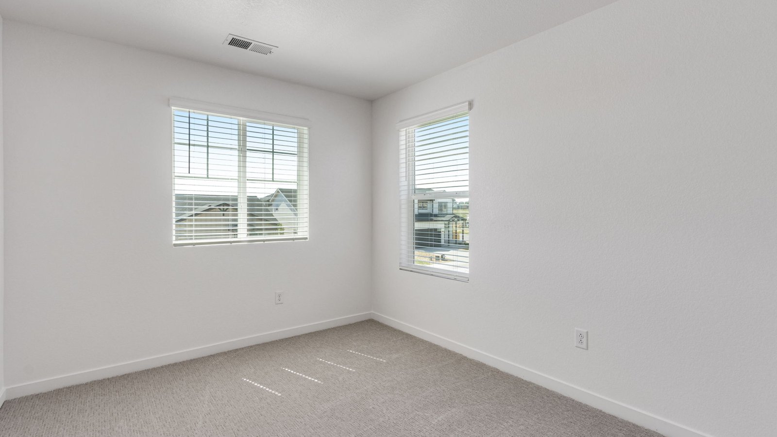 Bright guest bedroom in the Edmon home featuring natural light and ample room for furnishings.