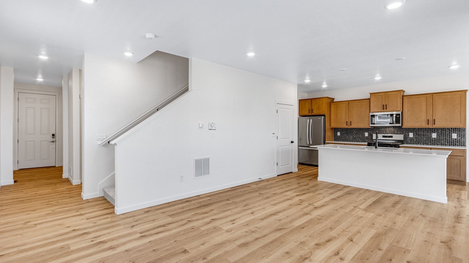 Bright and inviting great room in the Edmon floor plan connected to the kitchen and dining areas.
