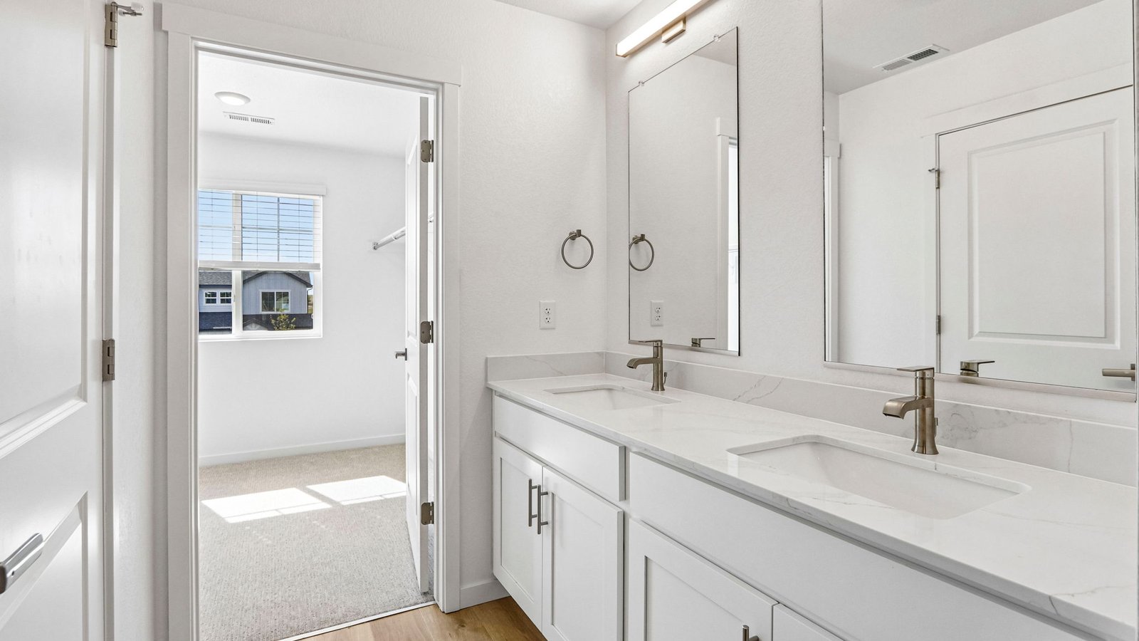 Designer-inspired primary bathroom featuring dual vanities and modern finishes.