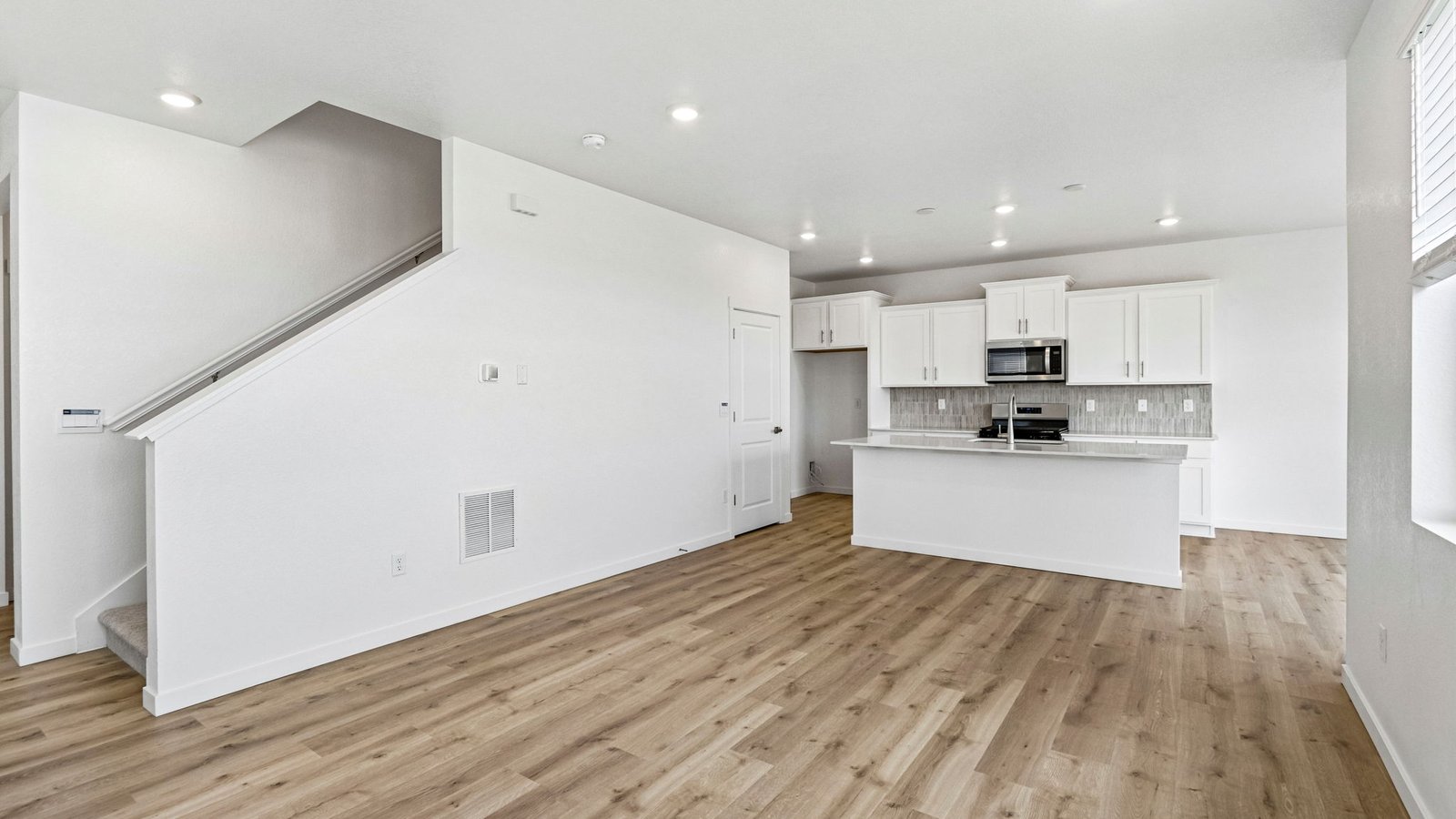 Bright family room with large windows and seamless connection to the kitchen.