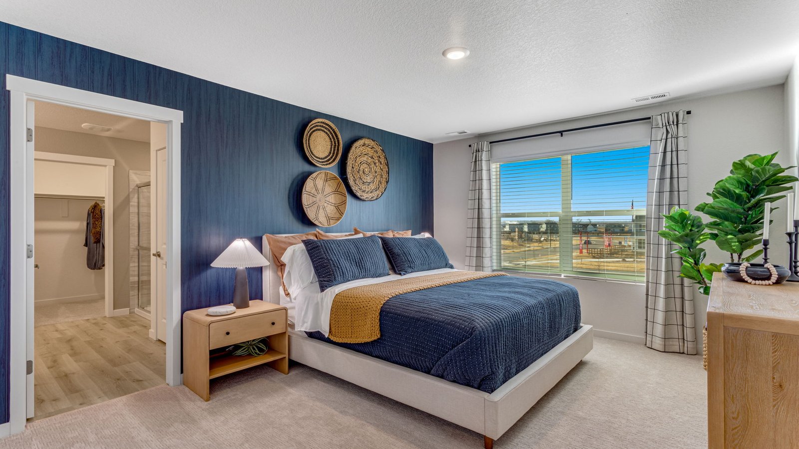 Spacious primary suite in the Pine floor plan featuring large windows, dual walk-in closets, and a private ensuite bathroom.