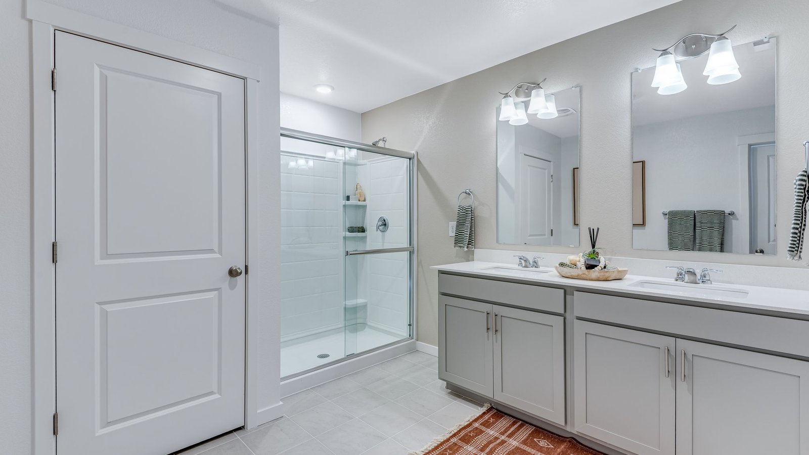 Primary bathroom with double vanity, elegant cabinetry, and private ensuite design.