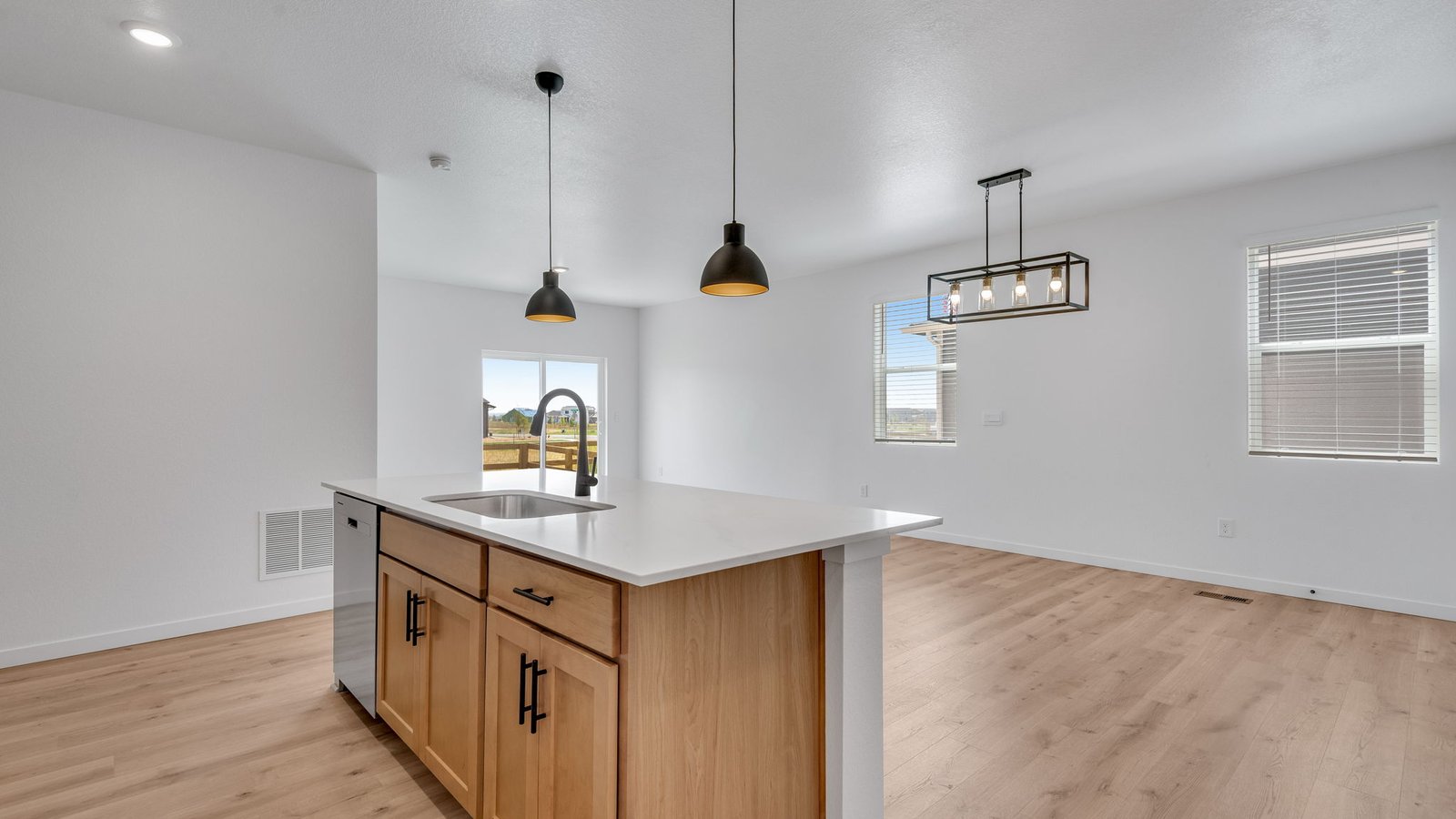 Open kitchen with spacious island and contemporary finishes in the Elm home at Prairie Song.