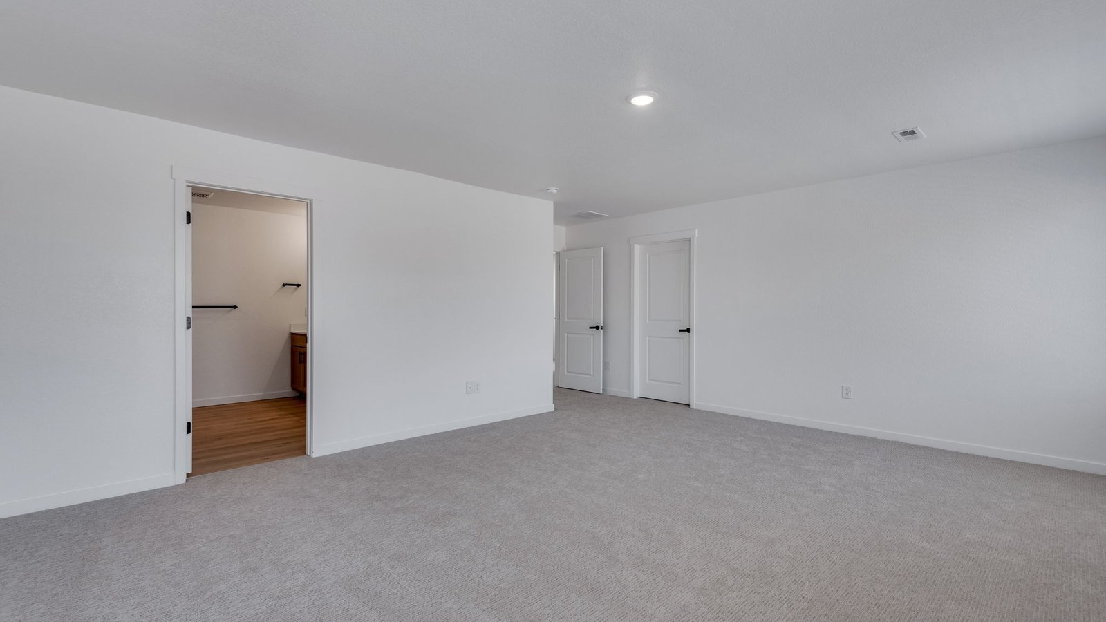 Large primary bedroom designed as a peaceful retreat in this Prairie Song home.