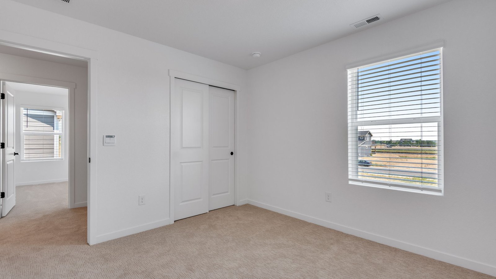 Comfortable guest bedroom with modern finishes and ample closet space.