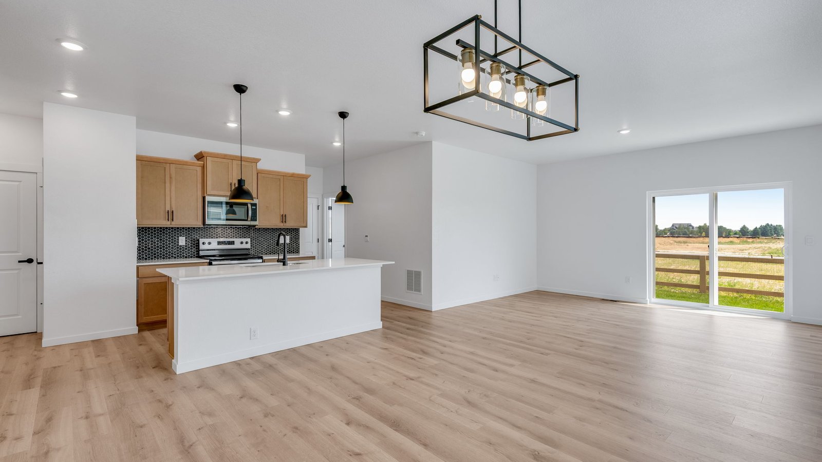 Bright living room connected to the kitchen and dining areas in the Elm home at Prairie Song.