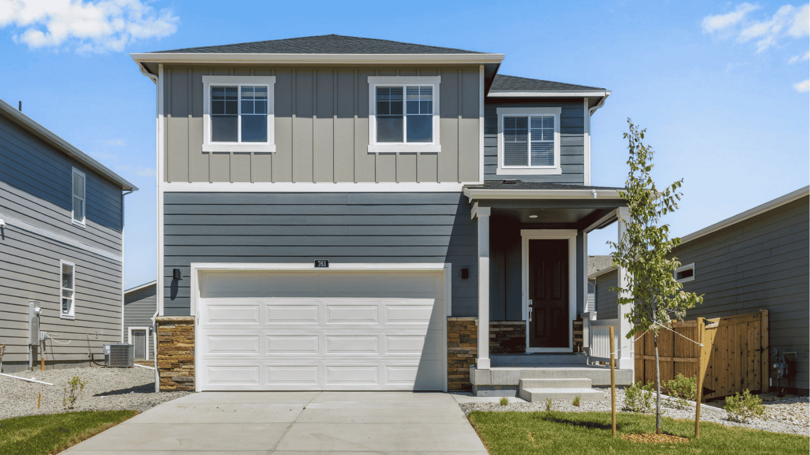 Exterior view of the Edmon floor plan at Granary in Johnstown featuring a modern façade, attached garage, and landscaped front yard.