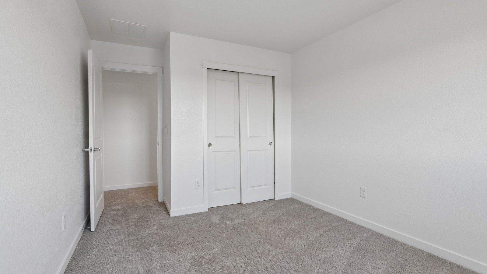 Bright upstairs bedroom featuring a versatile layout and ample closet space.