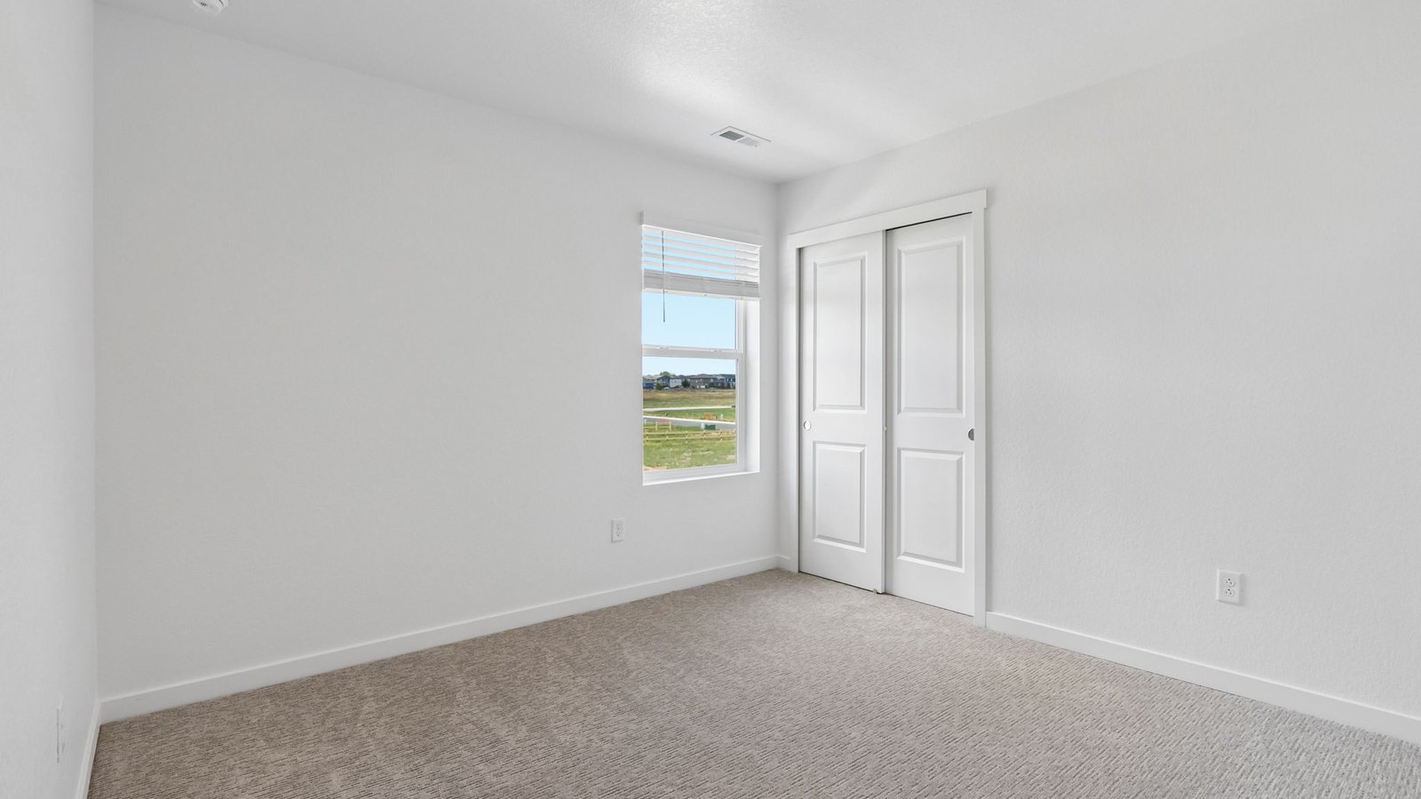 Spacious guest bedroom with attractive finishes and abundant natural light.