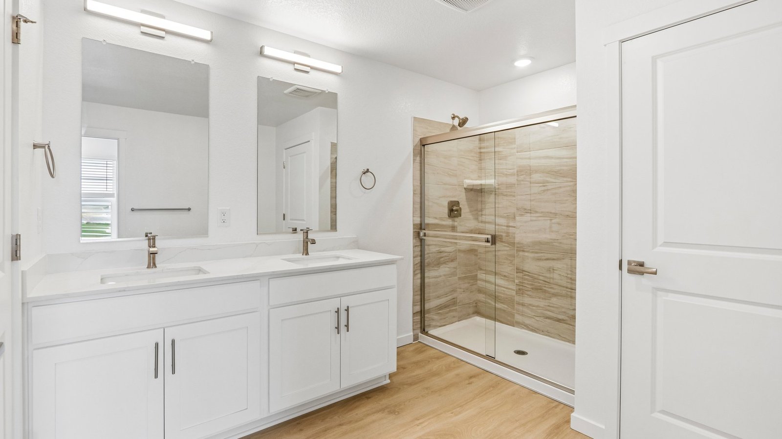 Attached primary bathroom with dual vanity sinks in new home in Johnstown Colorado