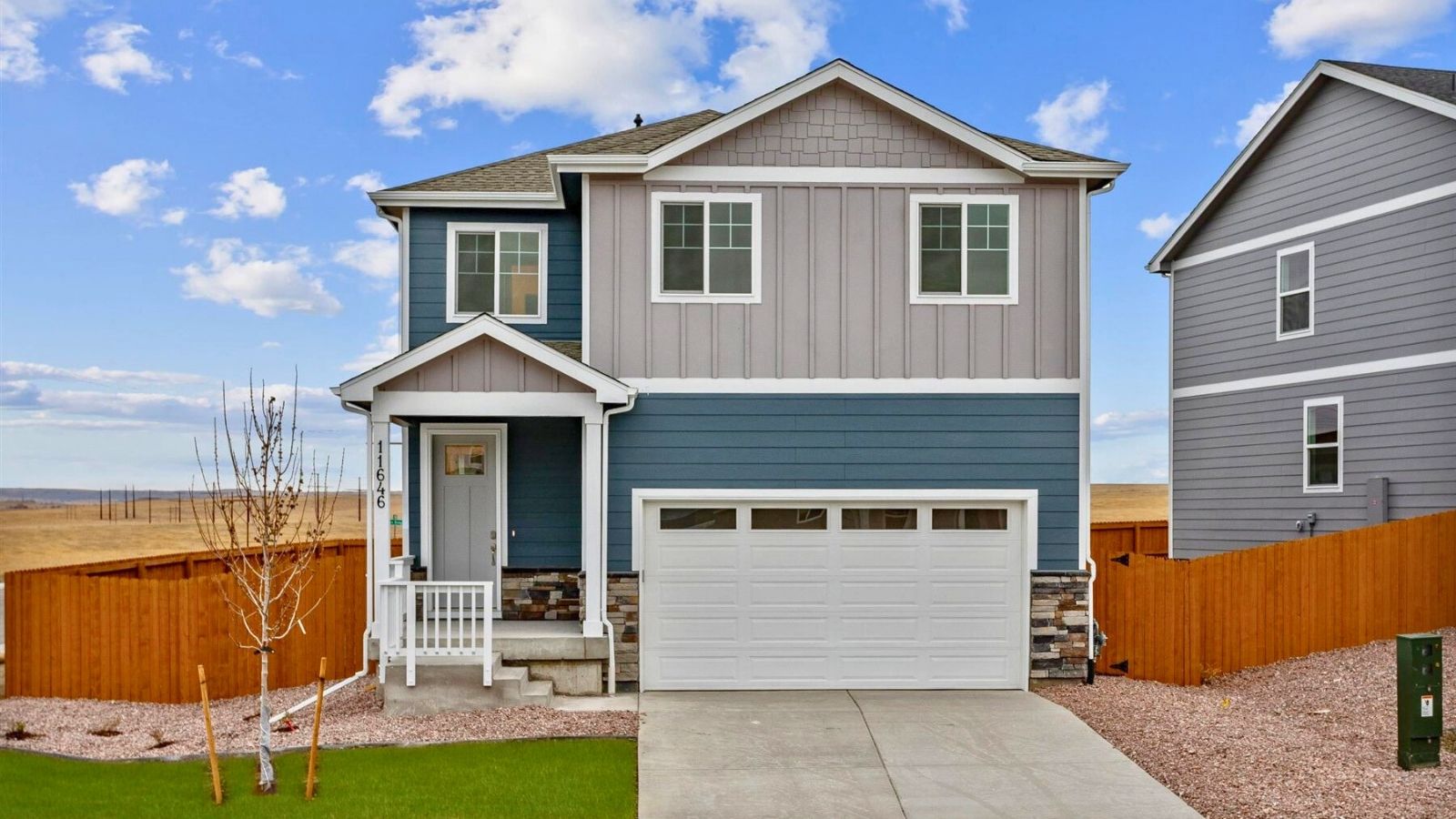 Exterior view of the Edmon floor plan in Silver Peaks featuring a modern façade, covered front entry, and landscaped front yard.