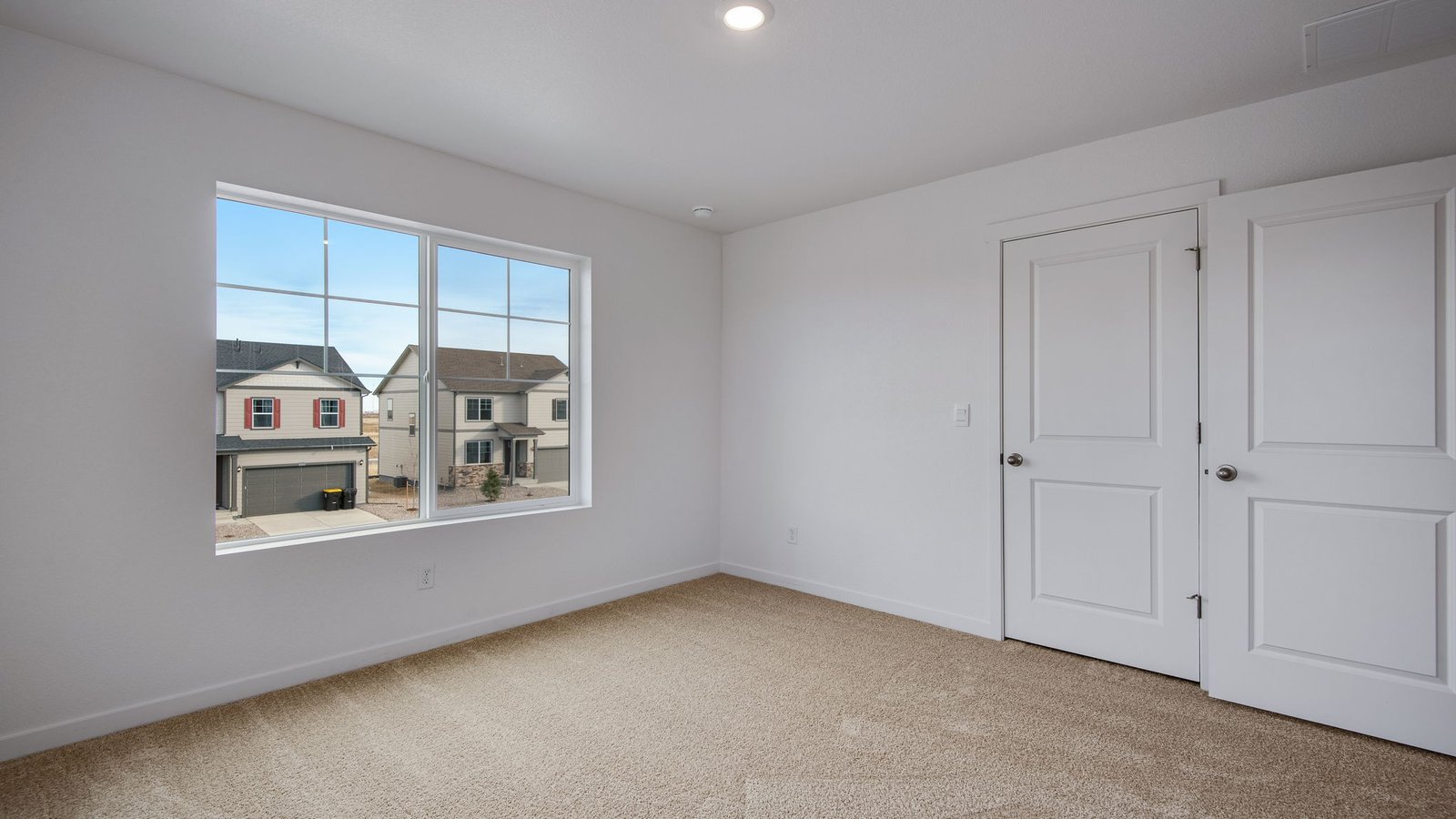 Large windows in secondary bedroom of new home in Lochbuie, Colorado