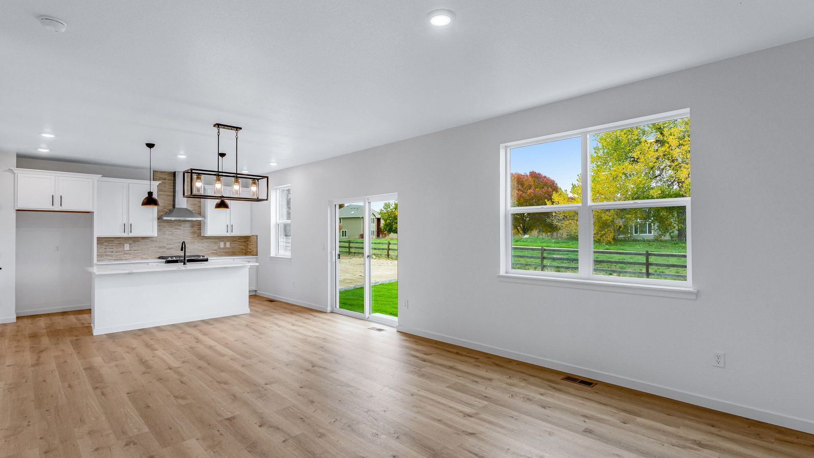 kitchen, dining, and living room with large windows in windsor new construction home