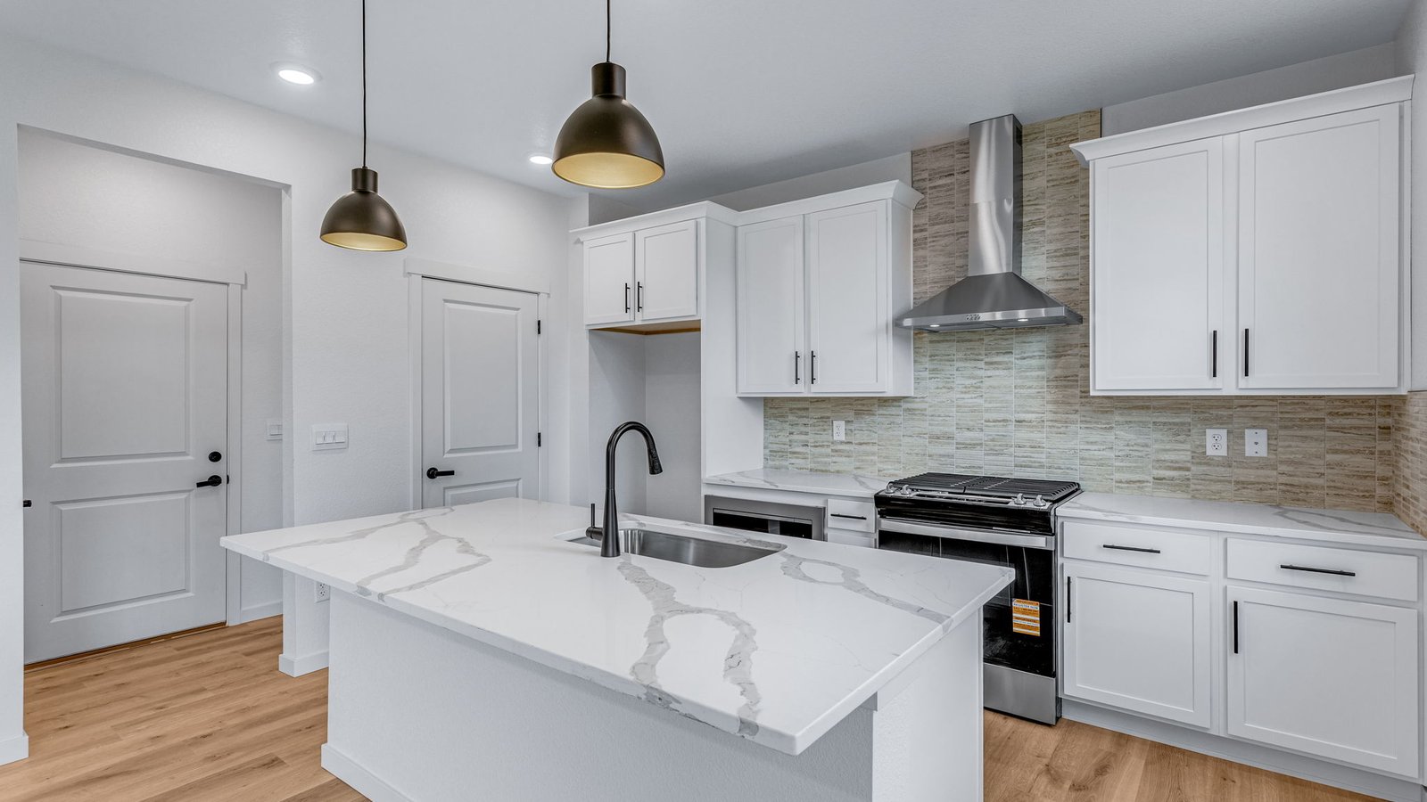 kitchen with black finishes and white cabinets in new construction home by d.r. horton