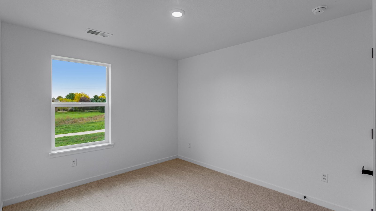 seconary bedroom with large window in new construction home by d.r. horton