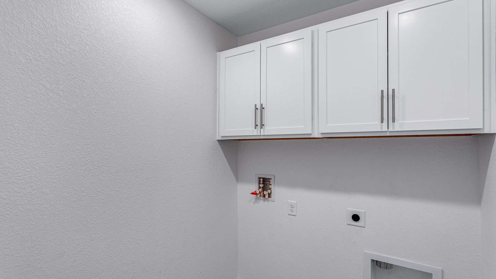 laundry room with upper cabinets in new construction home by d.r. horton