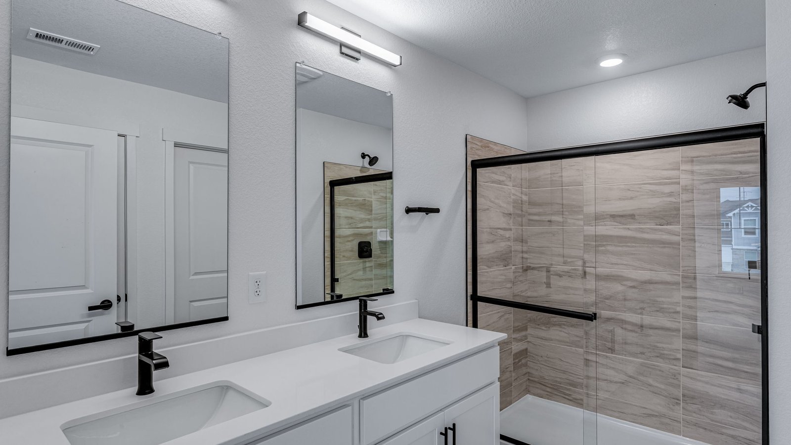 primary bath with black fixtures and shower in new construction home by d.r. horton
