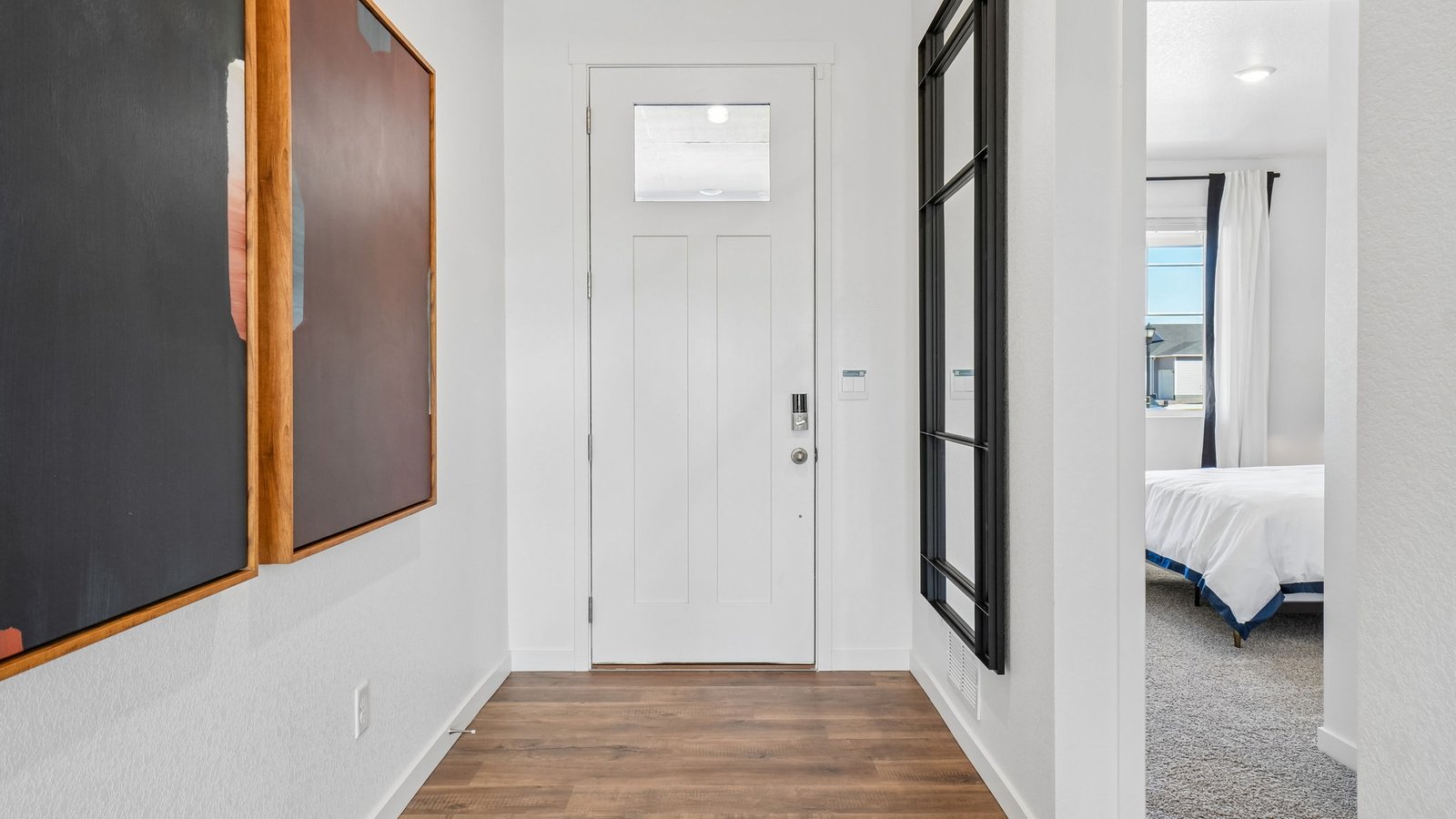 Bright and inviting foyer with soaring ceilings and easy access to the home's open-concept living areas.